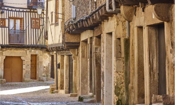 Imagen del pueblo medieval y tradicional de La Alberca, formado por fachadas de piedra y voladizos construidos con vigas de madera. La calle está totalmente empedrada. 