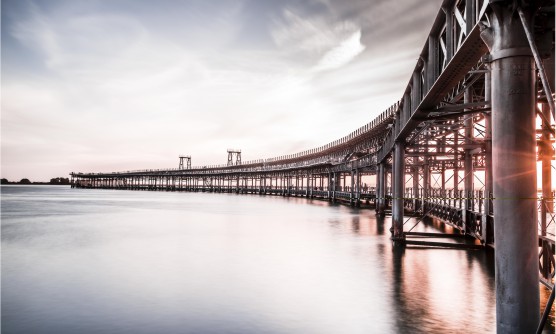 Imagen tomada durante el atardecer bajo el Muelle del Tinto sobre el río Odiel. Un muelle de carga por gravedad de hierro y madera, una obra de ingeniería construida en 1974 rehabilitado en 2007 para el uso y disfrute de los ciudadanos  