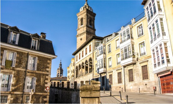 Centro de la ciudad de Vitoria en una de las calles más fotografiadas, una calle empinada que nos lleva hasta el casco antiguo y desde la cual podemos ver dos campanarios que emergen de entre varios edificios señoriales con bonitos invernaderos blancos, una porticada que cubre una gran  terraza y persianas blancas en ventanales verticales o en altillos.